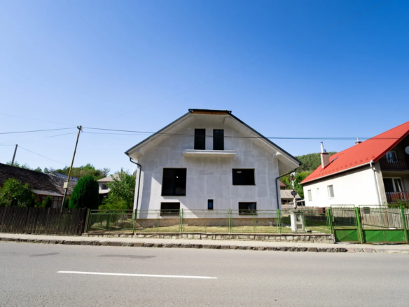 Čelná strana rodinného domu vo Fričovciach s oplotením pri ceste.