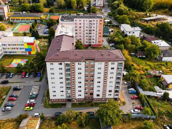 Letecký pohľad na bytový dom a okolité sídlisko.